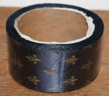 Roll with wide dark blue fabric ribbon golden French lilies, decoration